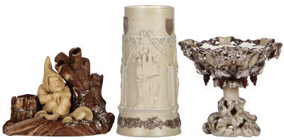 Three Mettlach items, cigar holder, 5.2" ht., 464, chips & tree ground, looks very good; with, beaker, 7.6" ht., 33, Köln Cathedral, #3365, crack repaired; with, bowl, 5.8" ht., 346, stem glued.