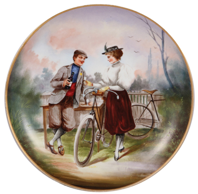 Porcelain plaque, 14.3'' d., hand-painted, French, man & woman with bicycles, 1'' chip on rear hanging rim [does not touch hanging holes], otherwise mint.