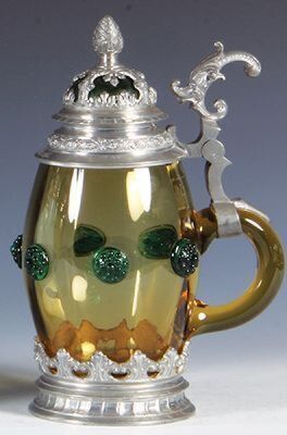 Two glass steins, .5L, blown, clear, wheel-engraved, matching glass inlaid lid, mint; with, .5L, blown, amber, applied green glass prunts, matching glass inlaid lid with overlay, mint. - 6