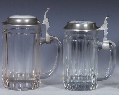 Two glass steins, .5L, pressed, porcelain inlaid lid: McTague's, old good pewter repair; with, .5L, pressed, porcelain inlaid lid: E.O. Rank, IIII Grand Ave., small base chip. - 2