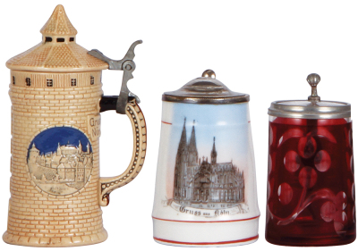 Three steins, Character, 5.7'' ht., pottery, Nürnberg Tower, mint; with, porcelain, 4.1'' ht., transfer, Gruss aus Köln, metal lid, mint; with, glass, 4.0''ht., blown, clear, red stain, clear glass inlaid lid, minor pewter tear in rear.